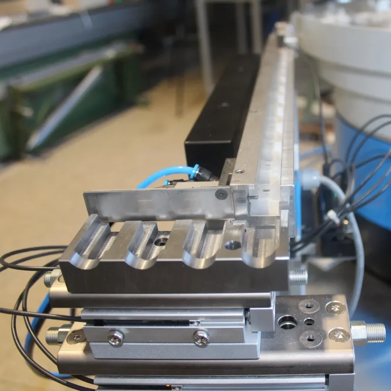 Bandbunker Förderband mit schmaler Metalltrichter, zur präzisen Materialdosierung in der Zuführtechnik.